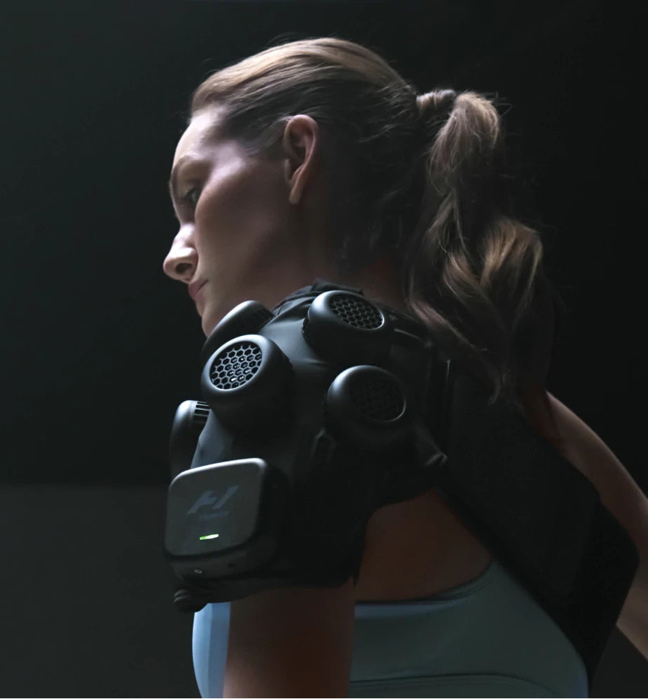 Woman wearing the Hyperice X Shoulder device for advanced hot and cold therapy.